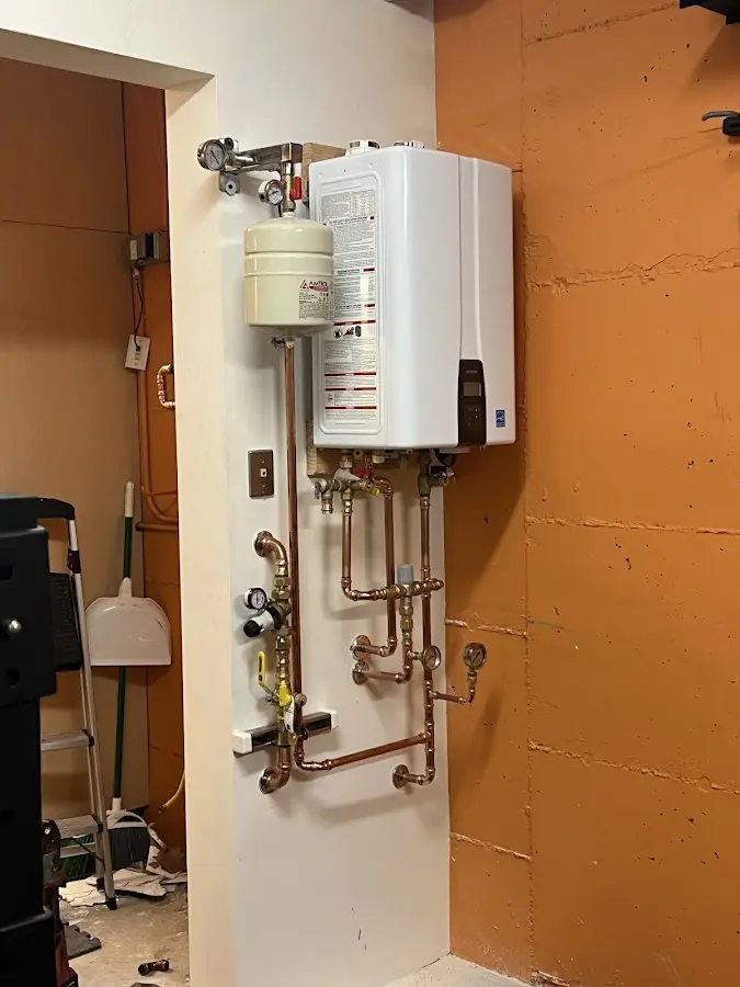 Plumbing technician inspecting water heater connections in Mead Valley